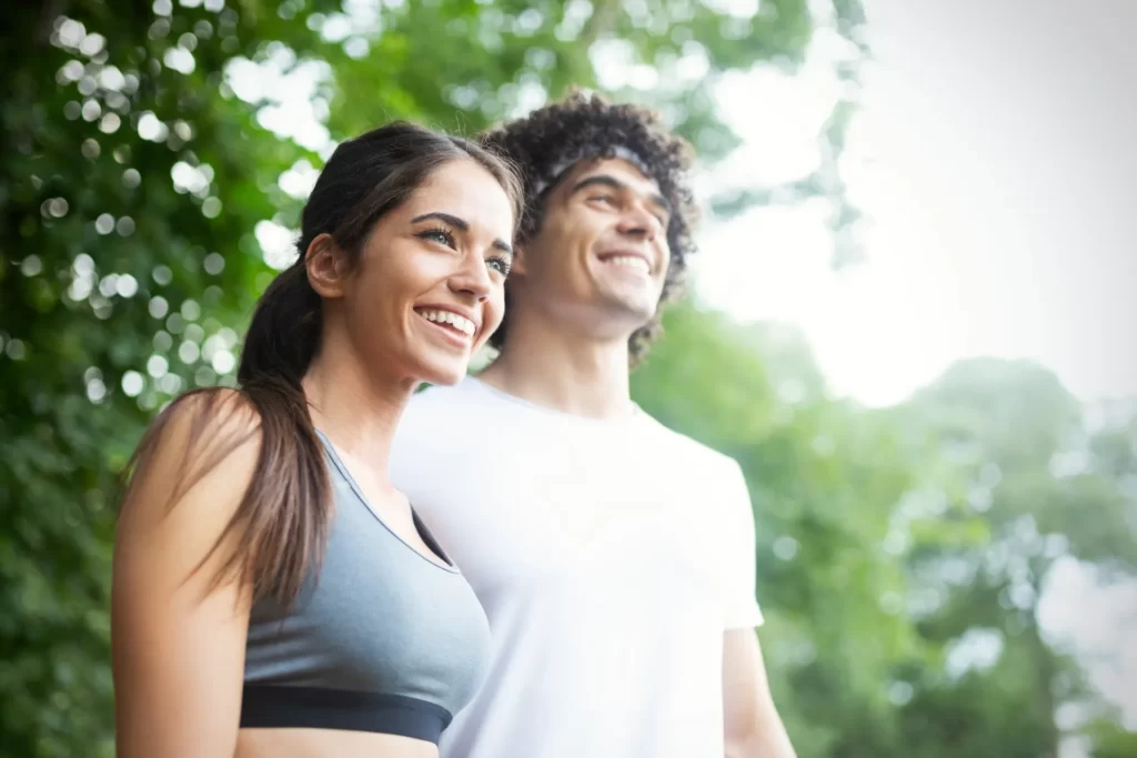 smiling young adults in athletic wear outdoors utc